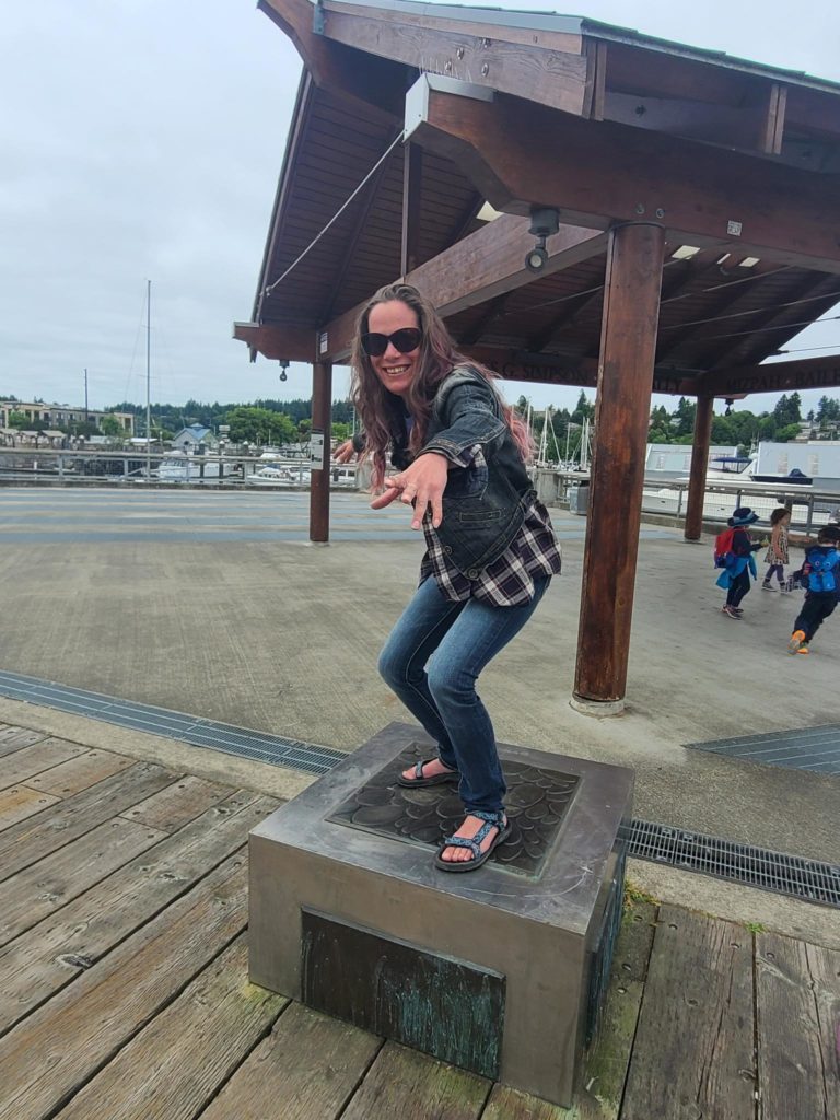 Sarah poses on a plinth at Percival like a surfer